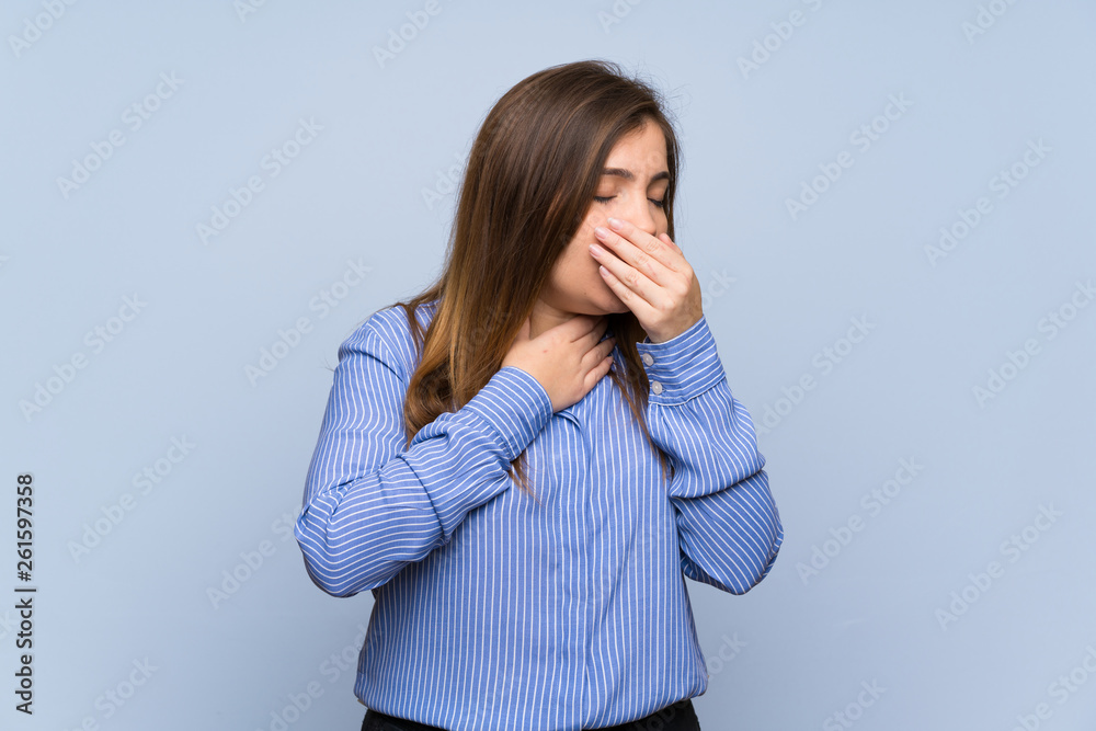 Young girl over isolated blue wall is suffering with cough and feeling bad Young girl over isolated blue wall is suffering with cough and feeling bad