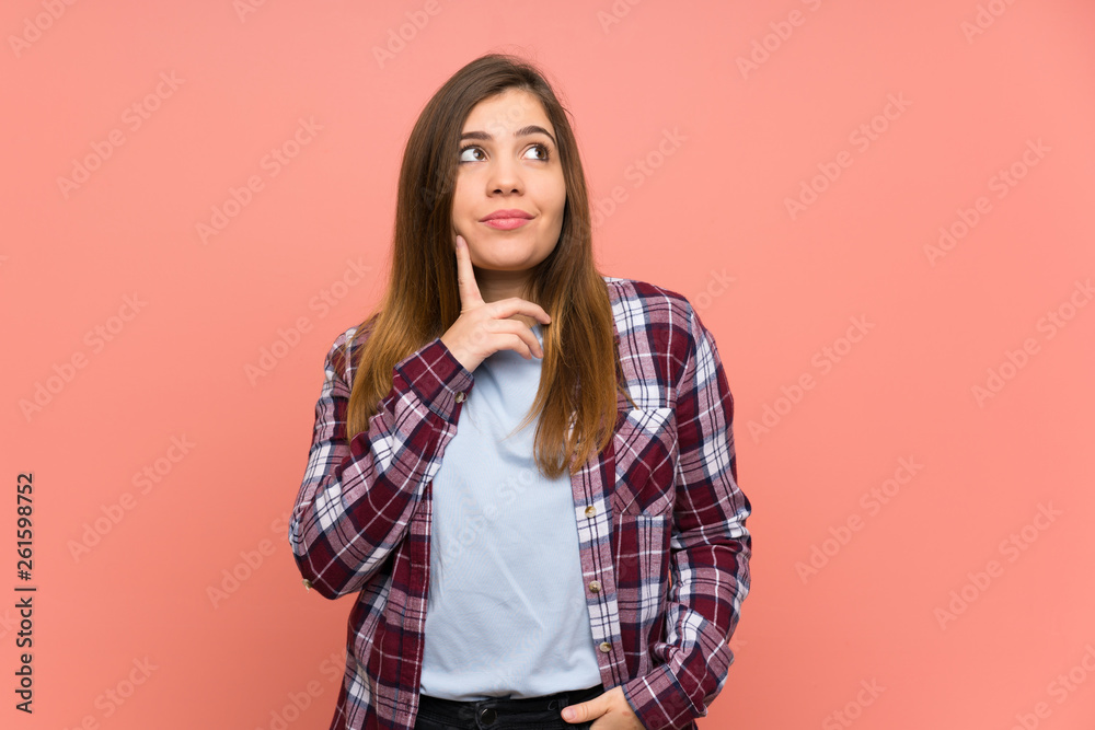 Young girl over pink wall thinking an idea while looking up Young girl over pink wall thinking an idea while looking up