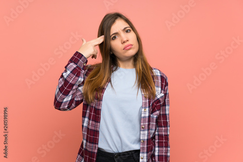 Young girl over pink wall with problems making suicide gesture