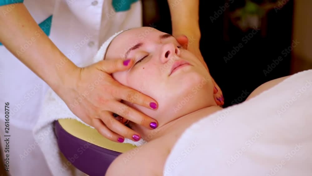 Hands beautician kneading the face of the girl lying on the couch in the Spa. Hands beautician kneading the face of the girl lying on the couch in the Spa.