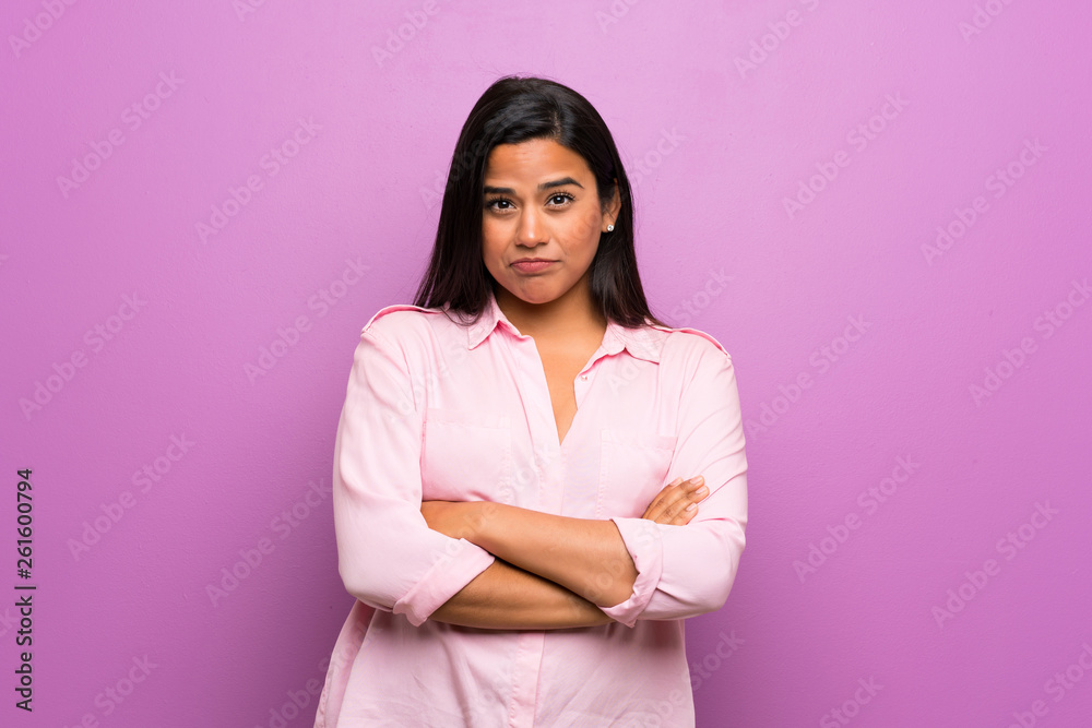 Fototapeta premium Young Colombian girl over purple wall feeling upset