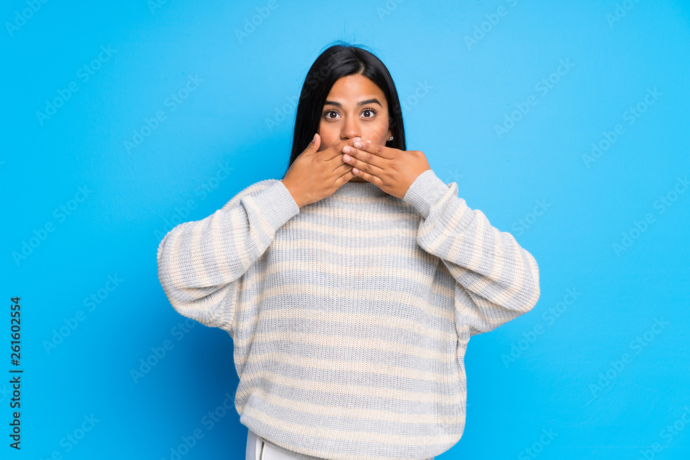 Young Colombian girl with sweater covering mouth with hands for saying something inappropriate Young Colombian girl with sweater covering mouth with hands for saying something inappropriate