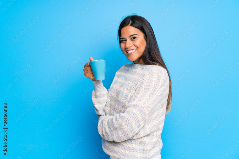 Young Colombian girl with sweater holding a hot cup of coffee Young Colombian girl with sweater holding a hot cup of coffee