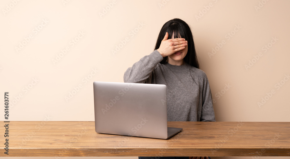 Young woman working with her laptop covering eyes by hands. Do not want to see something Young woman working with her laptop covering eyes by hands. Do not want to see something