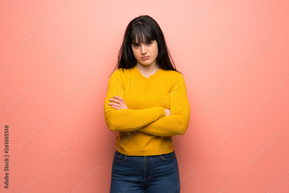 Fototapeta premium Woman with yellow sweater over pink wall feeling upset