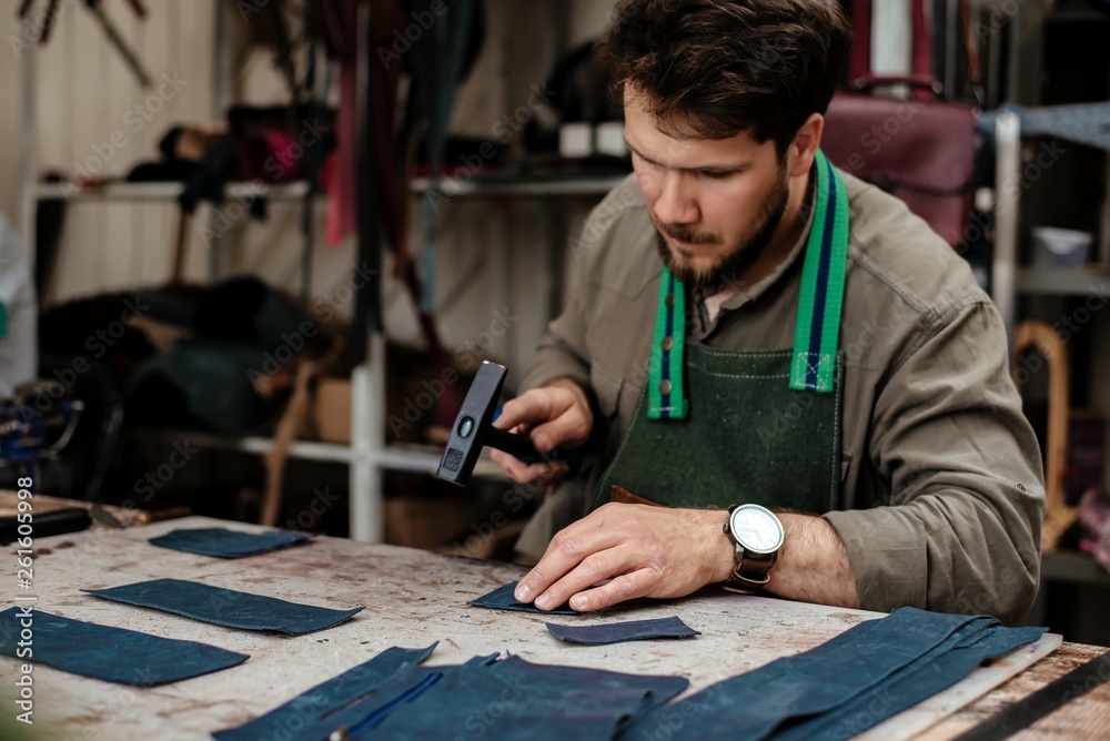Fototapeta premium A master works with genuine leather making exclusive things