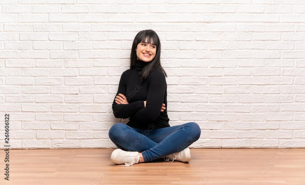Woman sitting on the floor with arms crossed and happy Woman sitting on the floor with arms crossed and happy