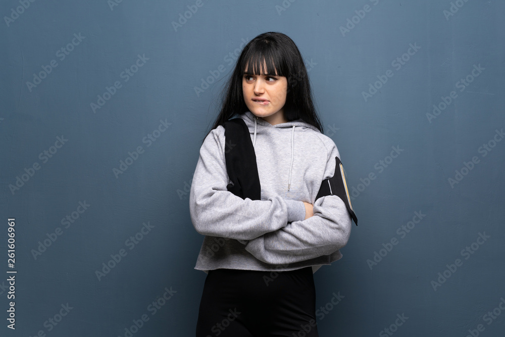 Young sport woman with confuse face expression while bites lip