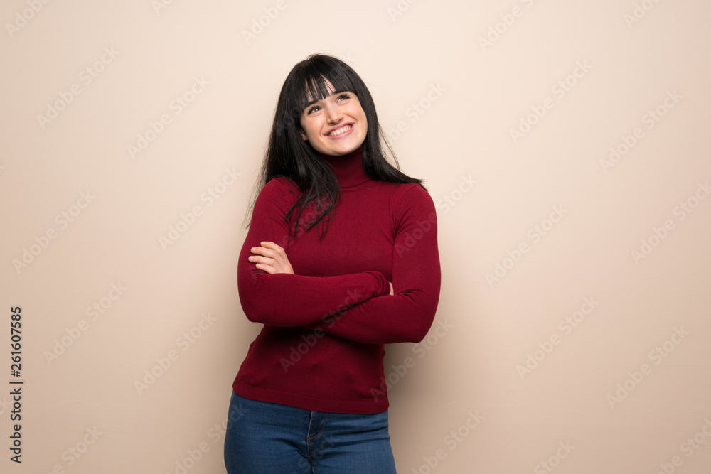 Young woman with red turtleneck looking up while smiling Young woman with red turtleneck looking up while smiling