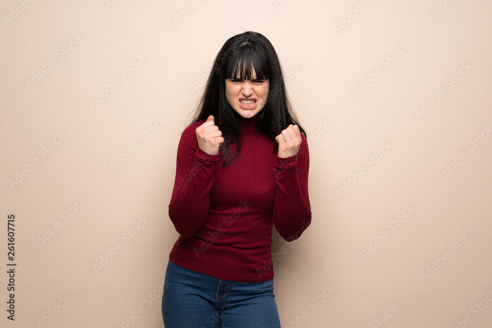 Young woman with red turtleneck frustrated by a bad situation Young woman with red turtleneck frustrated by a bad situation