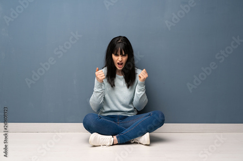 Woman sitting on the floor frustrated by a bad situation © luismolinero