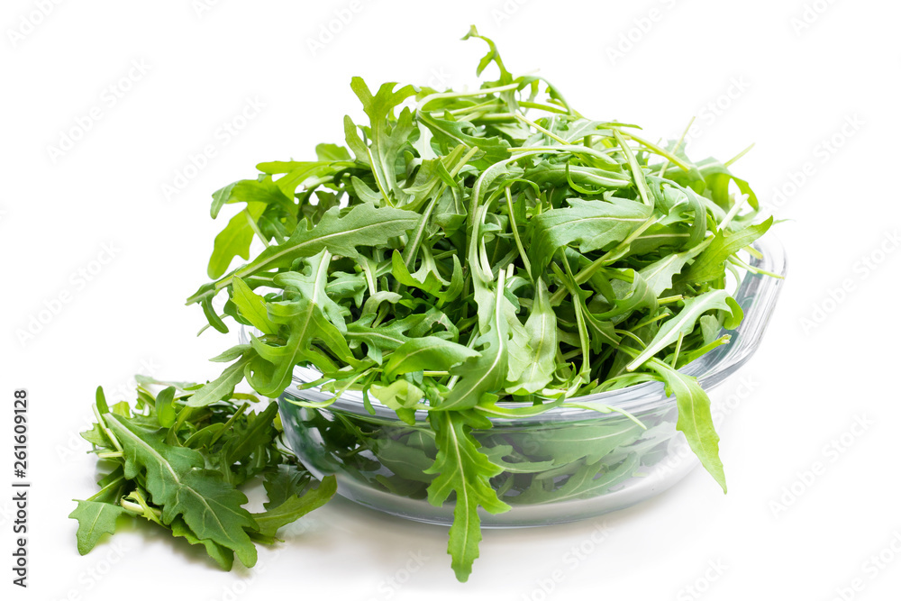 Rocket salad leaves in glass bowl isolated on white
