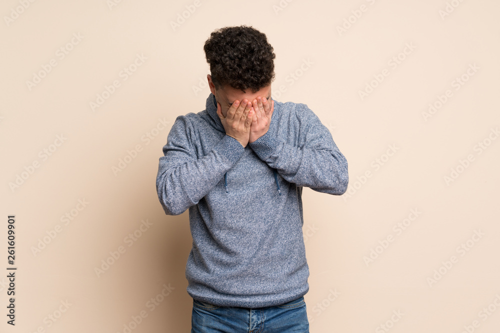Young man over isolated wall with tired and sick expression Young man over isolated wall with tired and sick expression