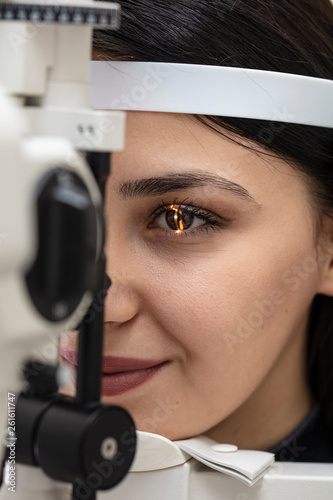 High technology concept health for eyes care - The optician ophthalmology doctor optometrist in the eyes clinic using a binocular slit-lamp to a young woman for an eye control.