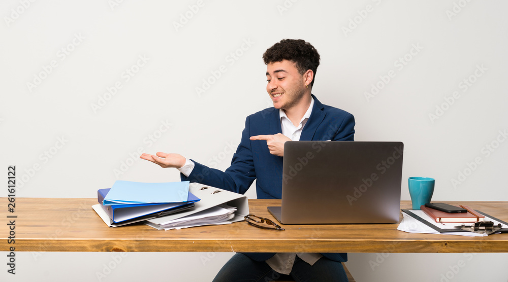 Business man in a office holding copyspace imaginary on the palm to insert an ad Business man in a office holding copyspace imaginary on the palm to insert an ad