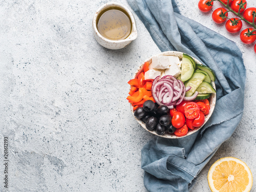 Greek Salad Bowl on gray cement background, copy space. Above view of Bowl Greek Salad. Trendy food. Idea, recept and concept of modern healthy food. photo