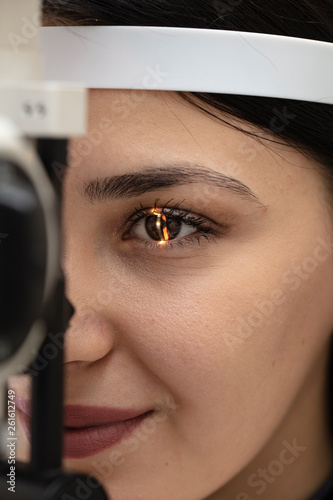 High technology concept health for eyes care - The optician ophthalmology doctor optometrist in the eyes clinic using a binocular slit-lamp to a young woman for an eye control. photo