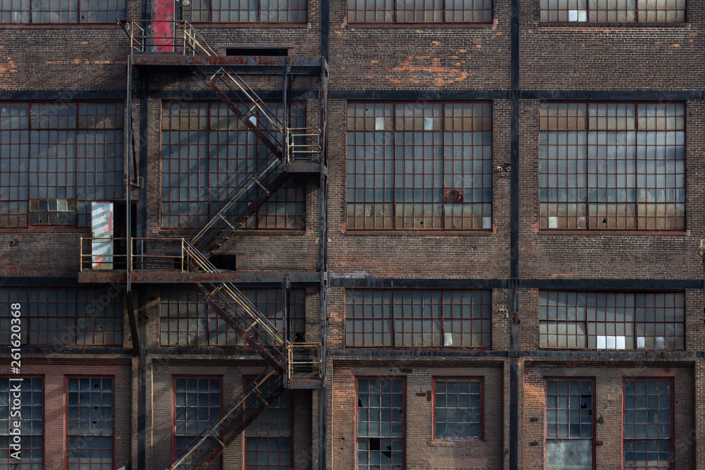 Windows, doors, and fire escape on the exterior of a derelict industrial building, horizontal aspect Windows, doors, and fire escape on the exterior of a derelict industrial building, horizontal aspect