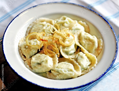 Delicious dumplings with cheese and onions in a bowl