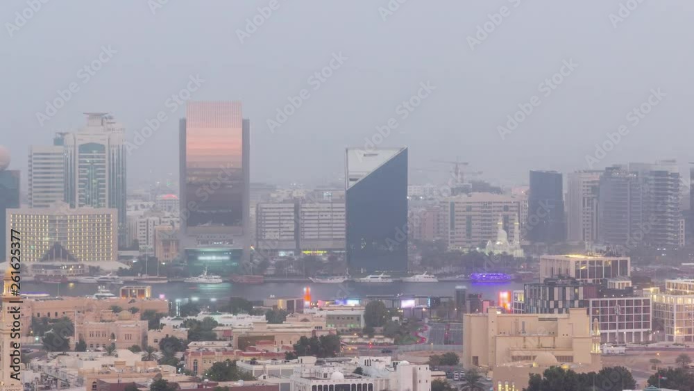 Deira modern and old buildings canal aerial view of Dubai Creek day to night transition timelapse. Hazy weather during sand storm Deira modern and old buildings canal aerial view of Dubai Creek day to night transition timelapse. Hazy weather during sand storm