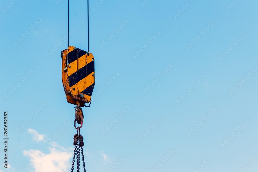 building construction: crane hook, chain and cables against the blue sky building construction: crane hook, chain and cables against the blue sky
