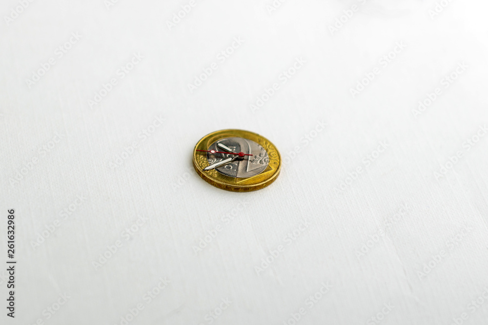 time and money, concept: second, hour and minute hands on a coin of 2 Belarusian rubles, on a light background, short focus time and money, concept: second, hour and minute hands on a coin of 2 Belarusian rubles, on a light background, short focus