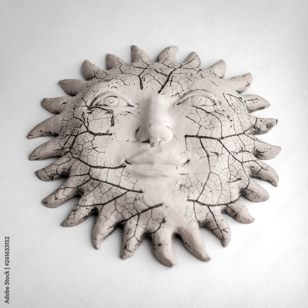 Fototapeta premium travel artifacts: antique ceramic sun with prominences, on a light background, short focus