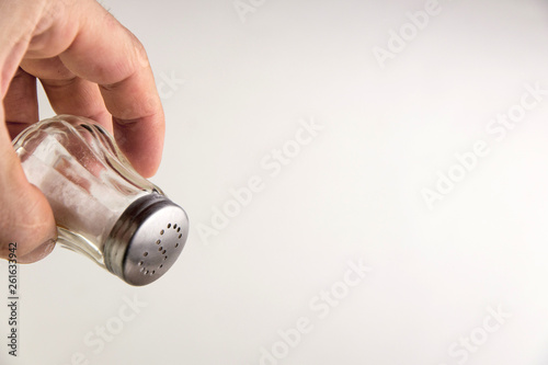 excess salt: saltcellar with the letter S in a man's hand, short focus