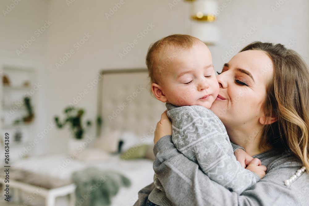 Beautiful young mother kissing her cute son Beautiful young mother kissing her cute son