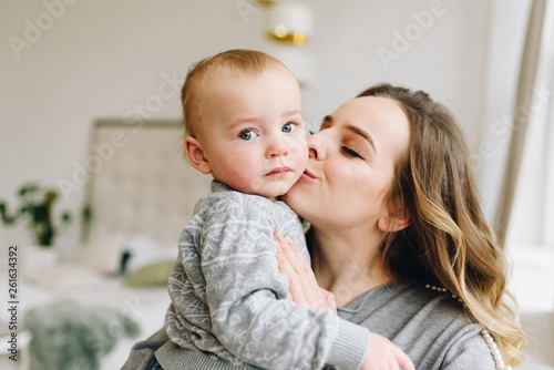 Beautiful young mother kissing her cute son
