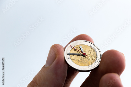 time of profitable investment: 2 euro coin with hour hands, short focus, toning, close