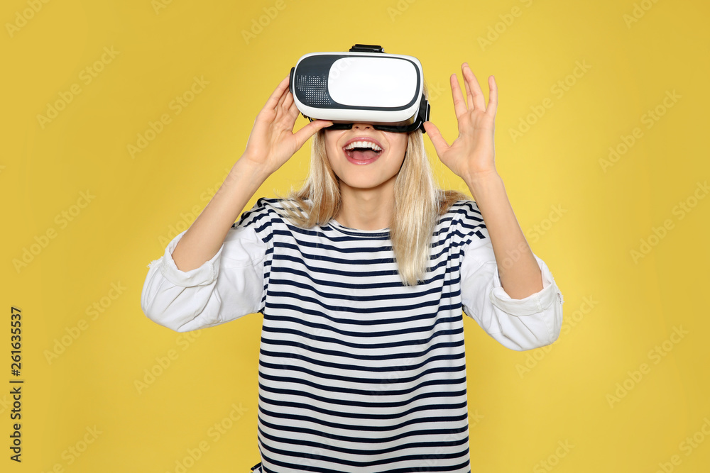 Emotional woman playing video games with virtual reality headset on color background Emotional woman playing video games with virtual reality headset on color background
