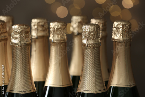 Many bottles of champagne on blurred background, closeup