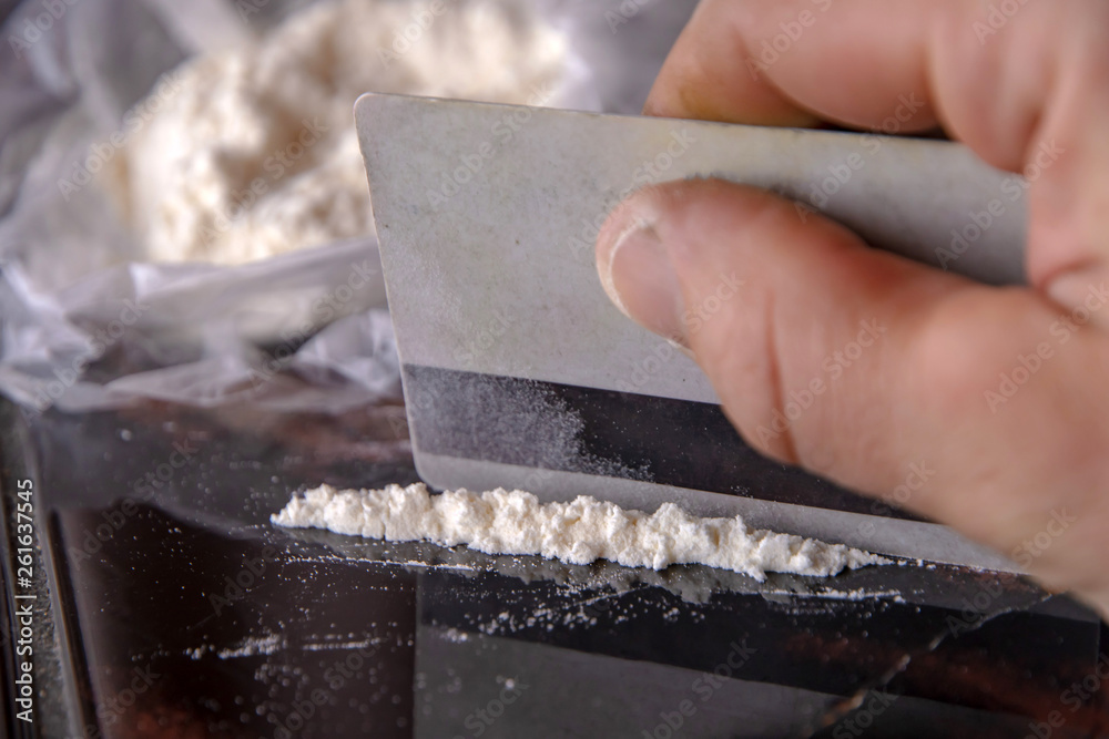 strip of cocaine on a background of packing with a drug and a plastic card strip of cocaine on a background of packing with a drug and a plastic card