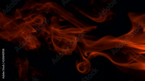 Vertical video screensaver - Fiery red smoke billow rising swirl up, isolated on black background. Colored smoke blowing from the right side. Closeup, isolated on black background. photo