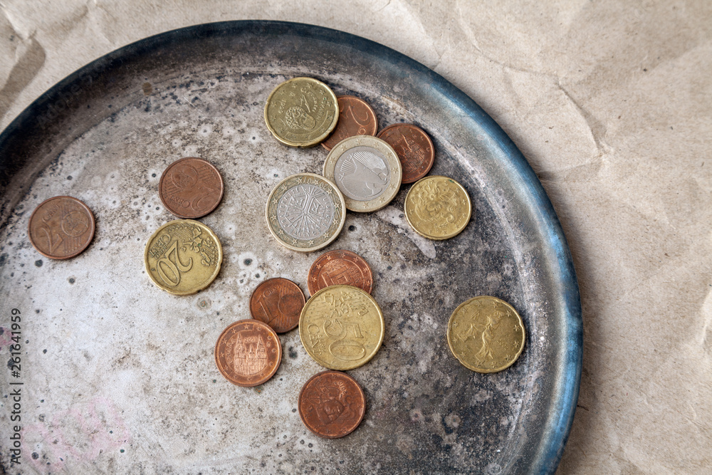 Some euro coins scattered on a metal dish close-up. Various money of the European Union from above Some euro coins scattered on a metal dish close-up. Various money of the European Union from above