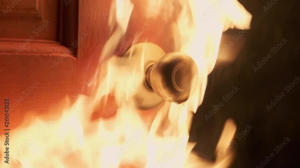 House door handle being lit with blazing hot fire and extinguishes slowly, close up side shot