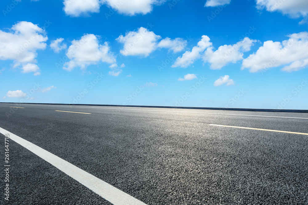 Fototapeta premium Empty asphalt road ground and blue sky with white clouds scene