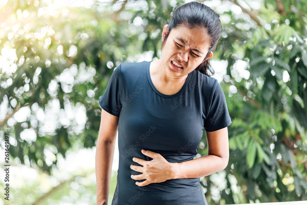 Young Asian women sport having stomach ache , health care concept