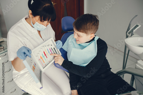 Little boy talking to the dendist. Child in the dentist s office. Woman in a uniform