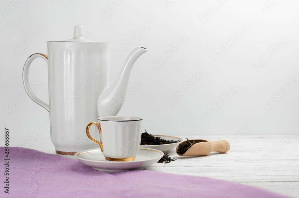 Teapot and cups on the wooden white table. Aromatic black tea. Concept of tea ceremony, break and having rest.