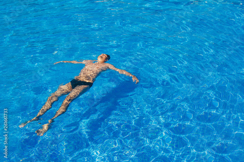 tanned man on vacation swimming in the pool