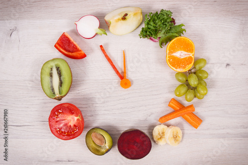 Fruits and vegetables in shape of clock showing time to healthy eating containing vitamins