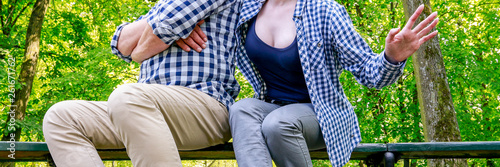 Angry couple sitting on the bench in beautiful summer park.