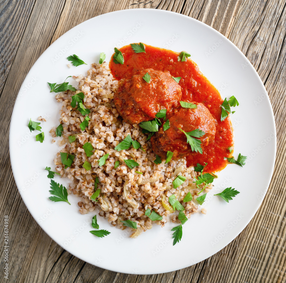 beef cutlets, tomato sauce, and buckwheat porridge with onion decorated with parsley beef cutlets, tomato sauce, and buckwheat porridge with onion decorated with parsley