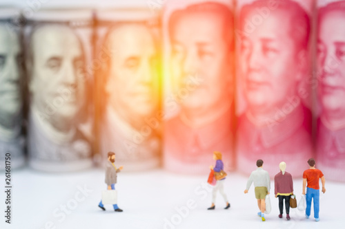 Shopping miniature figures with US dollar and China Yuan banknotes. After the 2 biggest increase tax for trade war which it effect to commerce and business.