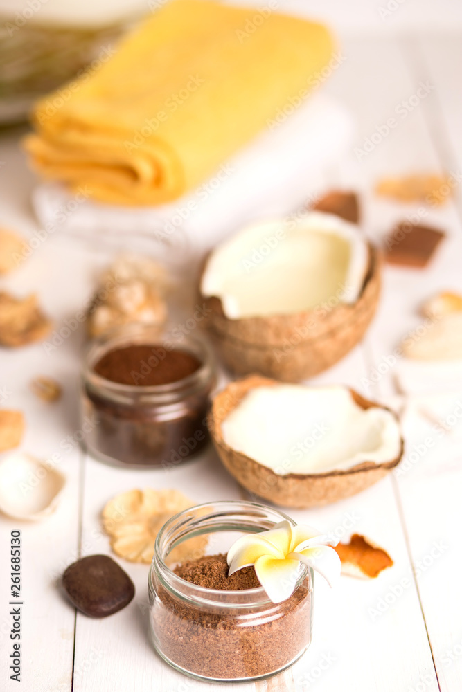 Coconut, spa products, coffee scrub and seashells on white background