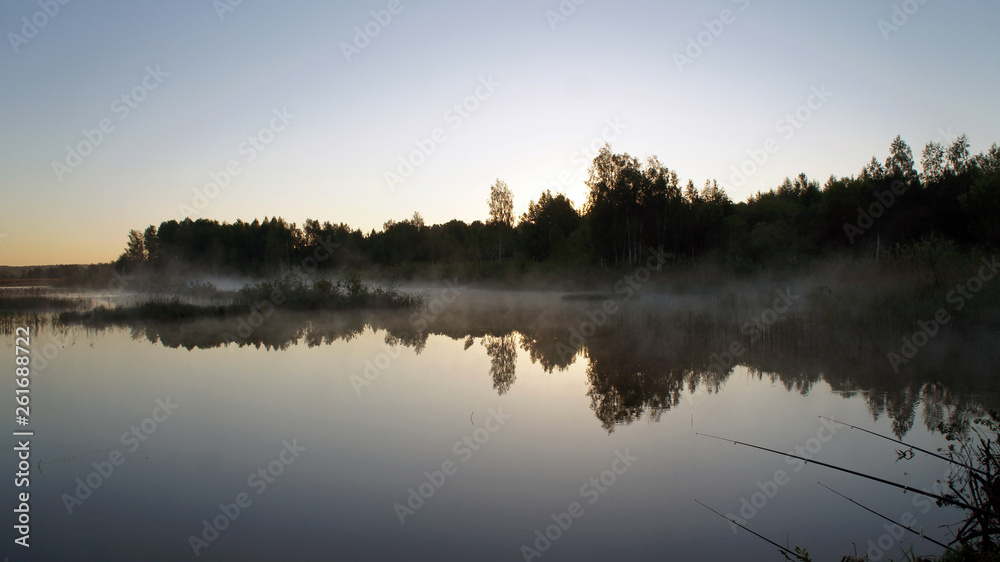 Morning dawn of the sun through the mist over the water. Early morning in the forest on the river.
