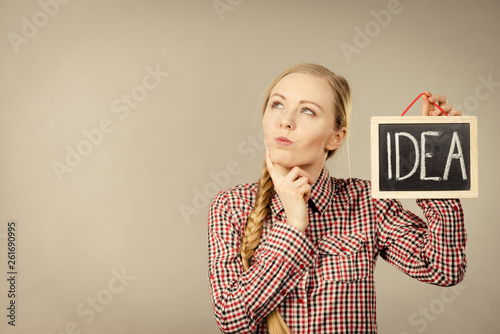 Thinking woman holding idea sign