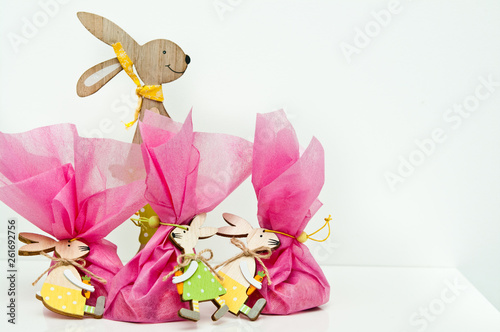 Easter gift with concept, wooden bunny toy with pink fabric wrapped package. © AHatmaker